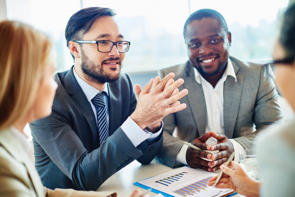 Two business professionals discussing strategy over documents