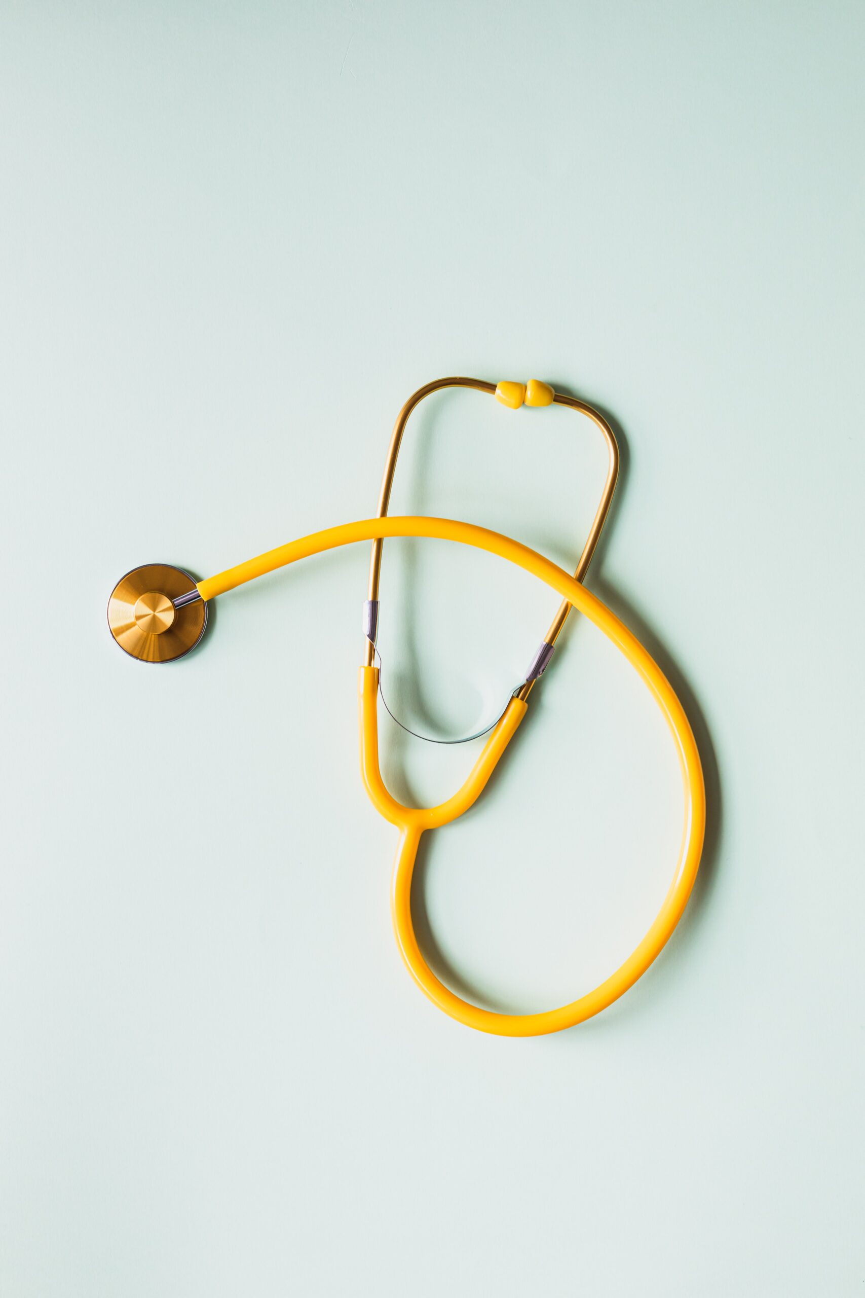 Yellow stethoscope on a light background